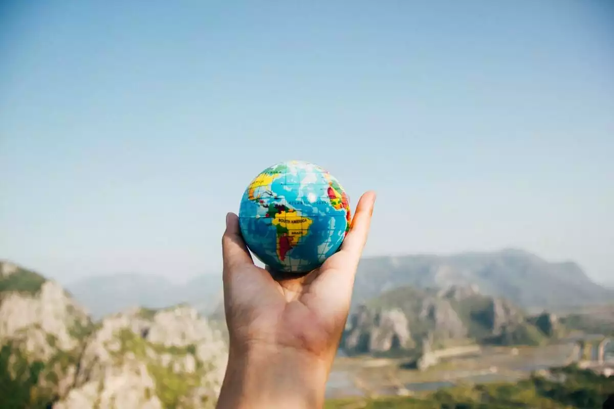Une main tenant une petite boule du monde