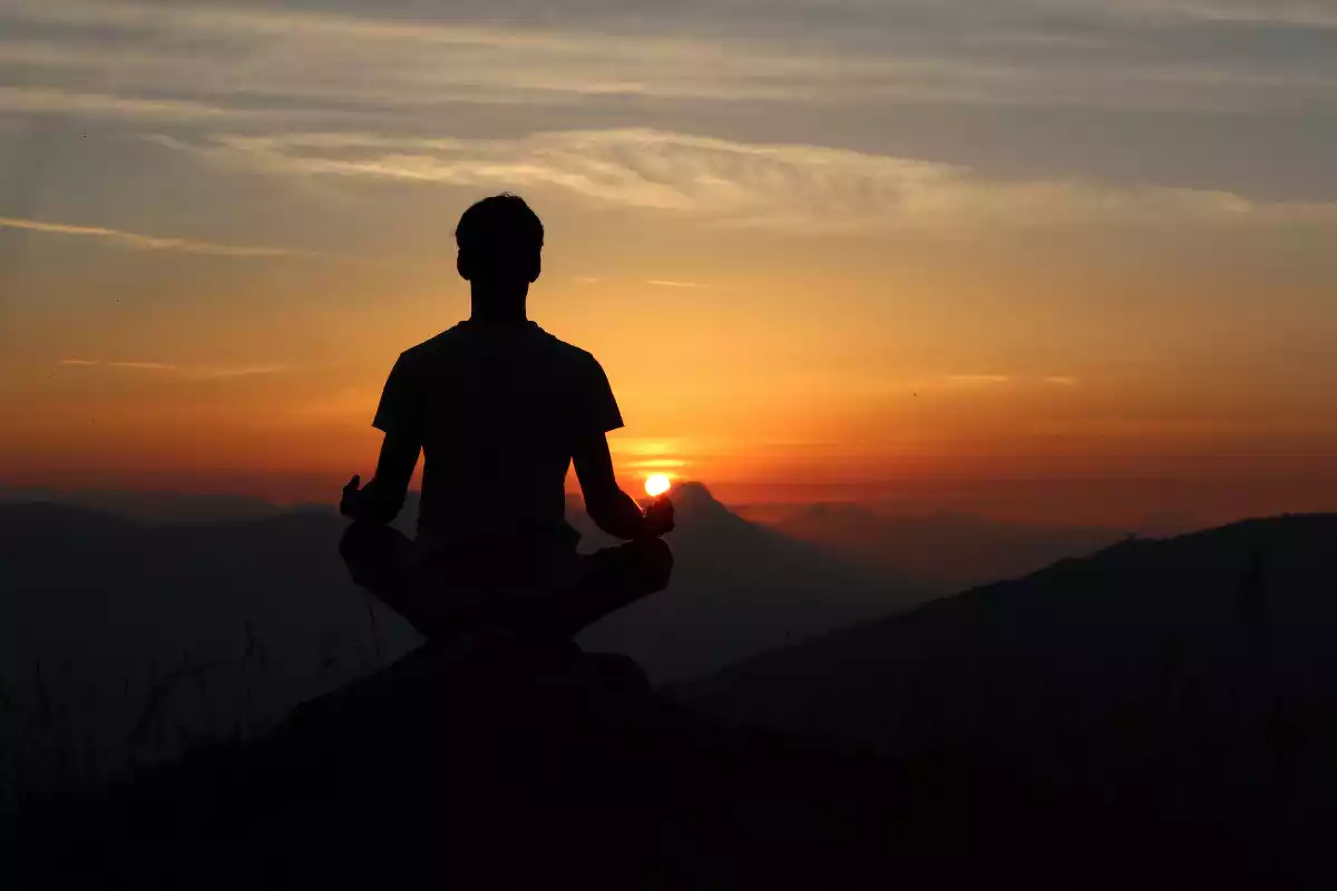 hombre de espaldas meditando en el amaner