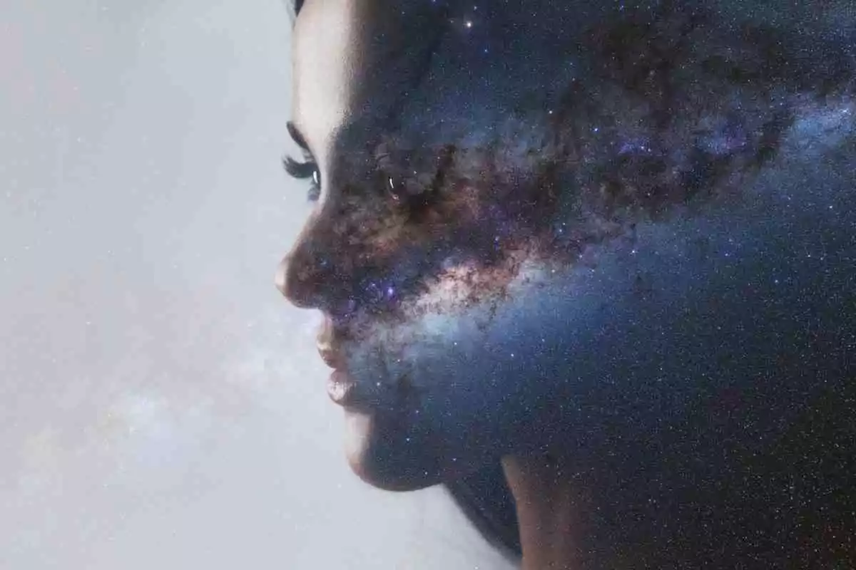 Une fille de profil avec l'univers en arrière-plan
