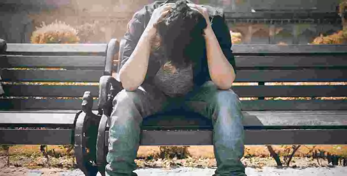 Un homme assis sur un banc s'inquiète