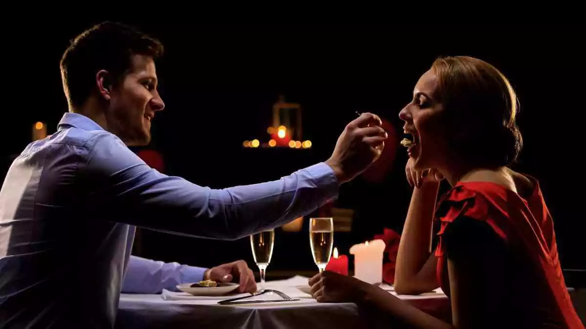 Un garçon met une cuillère de nourriture dans la bouche d'une fille
