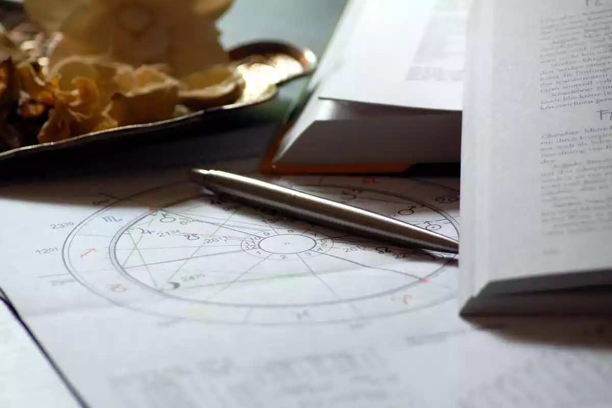Stylo posé sur un papier avec des informations astrologiques