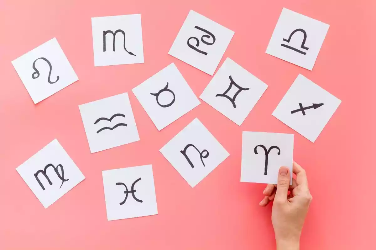 Papiers avec dessins des signes du Zodiaque sur fond rose